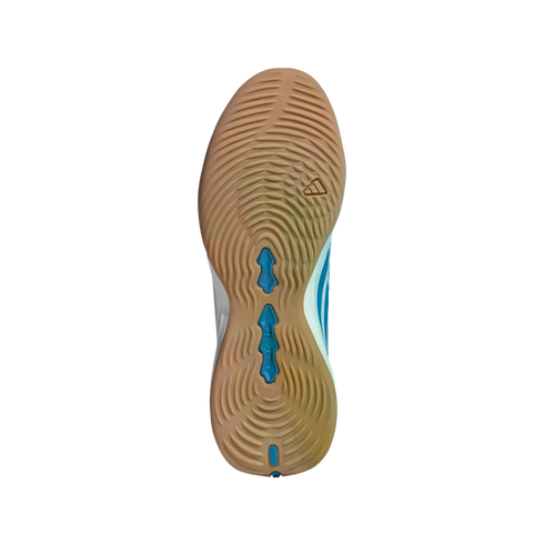 A gum-colored rubber sole of an Adidas Predator shoe with concentric circular tread patterns and blue inserts, shown against a solid black background.