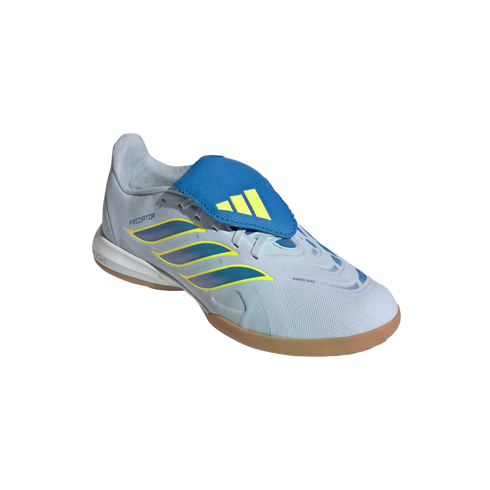 A side-angle view of an Adidas Predator indoor soccer shoe against a black background. The shoe features a light grey textured upper with three iridescent blue stripes outlined in yellow, a prominent blue fold-over tongue with a yellow Adidas logo, and a