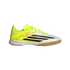 A side profile of a bright yellow and white Adidas indoor soccer shoe with black stripes and a gum rubber sole, set against a black background.