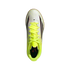 Top-down view of a white Adidas indoor soccer shoe with neon yellow laces and collar, featuring black and red accents on a solid black background.