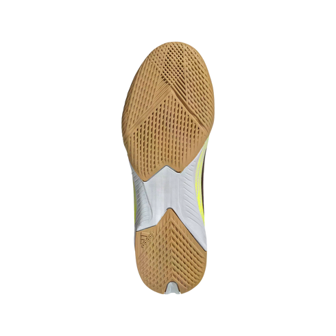 Bottom view of a tan and white Adidas athletic shoe sole with textured gum rubber tread on a black background.