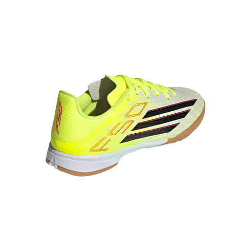 Neon yellow Adidas F50 indoor soccer shoe with black stripes, pink accents, white midsole, and gum rubber outsole on a black background.