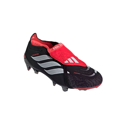 A black and red Adidas Predator soccer cleat with three silver stripes and a fold-over tongue, isolated against a solid black background.