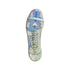 Bottom of an iridescent Adidas Predator soccer cleat with clear studs and a white strap across the forefoot, shown against a black background.