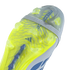 A close-up view of the neon yellow patterned outsole of an Adidas Predator soccer cleat, showing its various studs and a grey elastic strap against a solid black background.