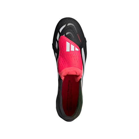 Top-down view of a black Adidas Predator soccer cleat featuring a prominent pink fold-over tongue and white accents against a solid black background.