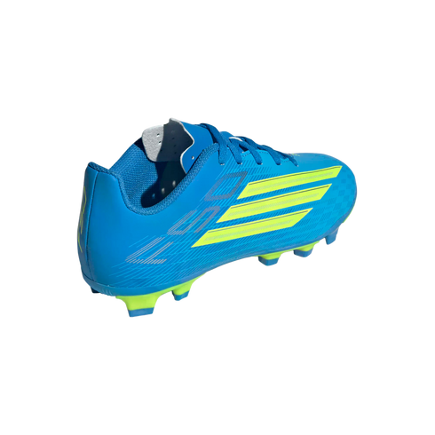 A blue soccer cleat with lime green accents, shown from a rear-quarter angle against a black background. The shoe features three diagonal lime green stripes on the side and a mixture of lime green and blue studs on the sole.