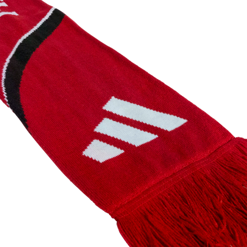 A red knitted scarf featuring a white three-stripe logo, a black and white curved stripe, and red tassels at the end.