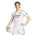 A man in a white Real Madrid kit poses with a soccer ball against a white background, holding the ball in one hand and resting the other on his hip.