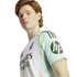 A young man wearing a white Real Madrid soccer jersey with an HP logo on the sleeve, posing against a plain white background.