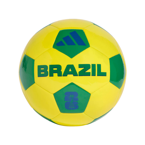 A yellow and green soccer ball is centered against a solid black background. The ball features the word "BRAZIL" in large green capital letters across its middle. Above the text is a blue Adidas logo on a green panel, and below it is a blue FIFA World Cup