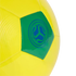 A close-up of a bright yellow soccer ball featuring a single green pentagonal panel. The green panel has a circular blue logo consisting of three swirling shapes inside concentric circles. The ball is set against a solid black background.