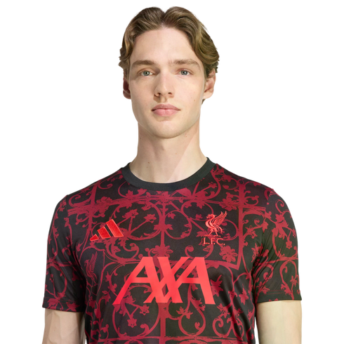 Young man in a black Liverpool FC training shirt with a red floral pattern, featuring the Adidas logo, L.F.C. crest, and AXA sponsor, set against a black background.