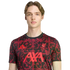 Young man in a black Liverpool FC training shirt with a red floral pattern, featuring the Adidas logo, L.F.C. crest, and AXA sponsor, set against a black background.