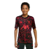 A young boy wearing a red and black patterned Liverpool FC training jersey, smiling against a solid black background.