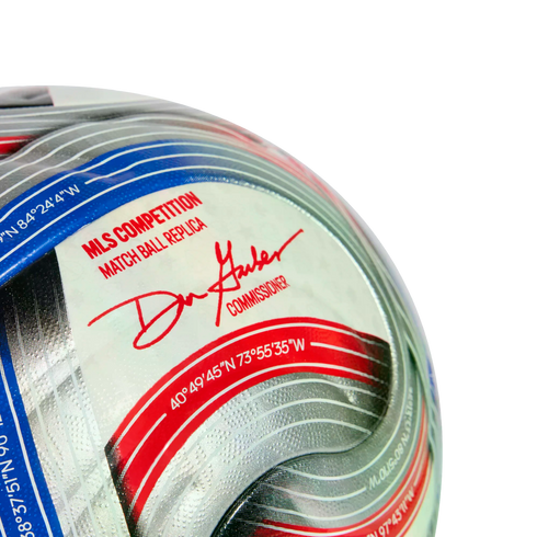 Close-up of an MLS match ball replica soccer ball featuring Commissioner Don Garber's signature and geographic coordinates on a silver, red, and blue graphic panel.