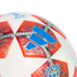 A close-up of a white Adidas soccer ball with orange star-shaped panels featuring intricate silver patterns and a prominent blue logo.