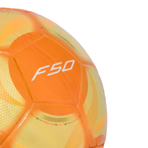 A close-up of a vibrant orange and yellow soccer ball featuring a white "F50" logo on its textured surface, isolated against a solid black background.