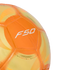 A close-up of a vibrant orange and yellow soccer ball featuring a white "F50" logo on its textured surface, isolated against a solid black background.