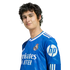 A headshot of soccer player Alvaro Rodriguez smiling, wearing a blue Real Madrid jersey with sponsor logos.
