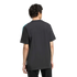 Back view of a man with curly hair wearing a black t-shirt with a teal and white shoulder stripe, against a solid black background.
