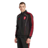 Man wearing a black Adidas Liverpool FC tracksuit with red stripes and white piping against a black background.