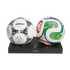 Two soccer balls on a black stand: a classic white Adidas Questra on the left and a colorful, modern Trionda on the right. The stand features the number 0137/2026.