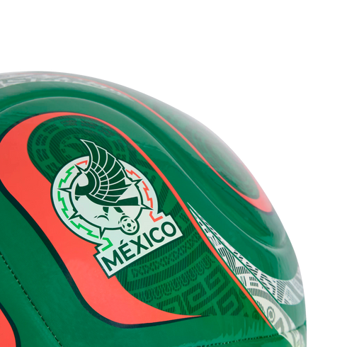 Close-up of a green soccer ball featuring the Mexico national football team crest and intricate red and white patterns.
