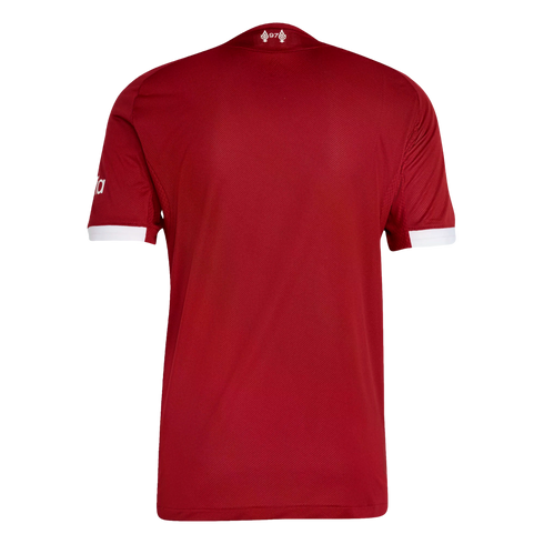 Back view of a red soccer jersey with white sleeve cuffs and a small white emblem at the back of the neck featuring the number 97 between two flames.