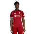 A young man wearing the red 2024-25 Liverpool F.C. home soccer kit, standing against a black background.