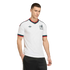 Man in a white Adidas Mexico soccer jersey with green and red trim, black shorts, and a silver chain against a black background.