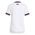 The back view of a white short-sleeve jersey with green and red trim on the collar and cuffs, featuring a small "Somos México" graphic centered at the top back.