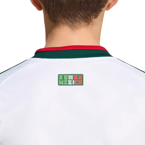 Back view of a white sports jersey with a green and red collar. A small logo below the collar reads "SOMOS MÉXICO" in stylized lettering with the colors of the Mexican flag.