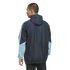 Man from the back wearing a navy blue and light blue hooded windbreaker jacket against a black background.