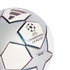 Close-up of a silver and white UEFA Champions League mini replica soccer ball with star panels and logos on a solid black background.