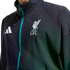 Close-up of a dark Adidas jacket featuring a teal zipper and the white Liverpool F.C. crest on the chest.