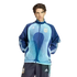 A man wearing a light and dark blue Argentina national team track jacket and matching pants by Adidas, standing against a solid black background.