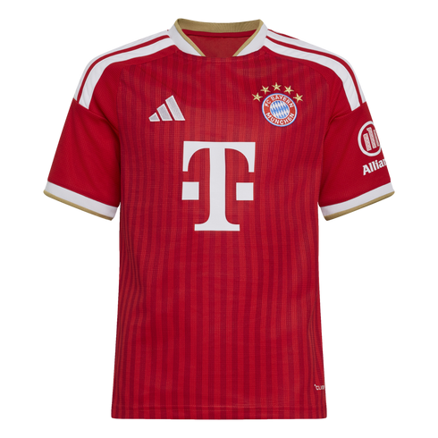 A red FC Bayern Munich football jersey with white and gold accents, featuring the team crest and a large white "T" sponsor logo on the front.