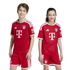 A boy and a girl smile wearing matching red FC Bayern Munich soccer uniforms, featuring the team's crest and sponsor logos, against a white background.