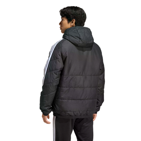 Rear view of a man wearing a black hooded puffer jacket and matching pants with white stripes, standing against a solid black background.