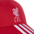 Close-up of a red baseball cap with a white embroidered Liverpool FC Liver Bird logo and "L.F.C." text, featuring three white stripes on the brim.