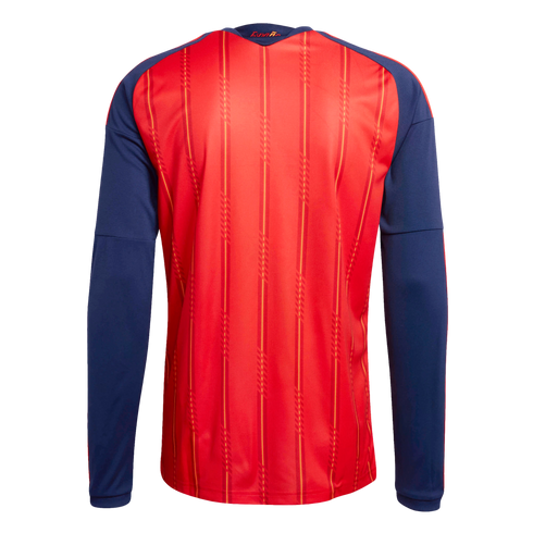 The back view of a red long-sleeved sports jersey with dark blue sleeves and thin vertical yellow stripes. A small gold "España" label is on the back of the neck.