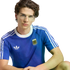 A young man with dark, wavy hair and gold-rimmed glasses wearing a blue Adidas Argentina national football team t-shirt against a black background.