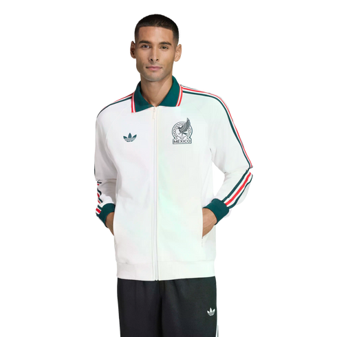 Man modeling a white Adidas Mexico track jacket with green and red accents and a Mexico crest, paired with dark pants against a black background.