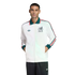 Man modeling a white Adidas Mexico track jacket with green and red accents and a Mexico crest, paired with dark pants against a black background.