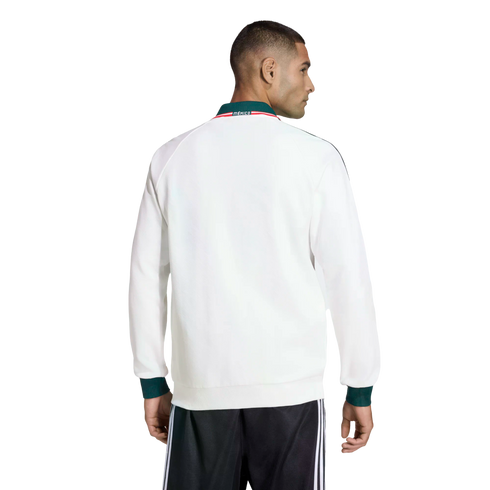 Rear view of a man in a white track jacket with green cuffs and a 'MÉXICO' collar, paired with black track pants against a black background.