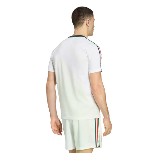 Rear view of a man wearing a white athletic t-shirt and matching shorts set, featuring green, red, and white stripes down the sleeves and sides, set against a black background.
