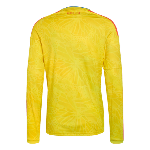 Back view of a yellow long-sleeved soccer jersey with a tonal butterfly pattern, orange stripes, and "COLOMBIA" printed on the upper back.