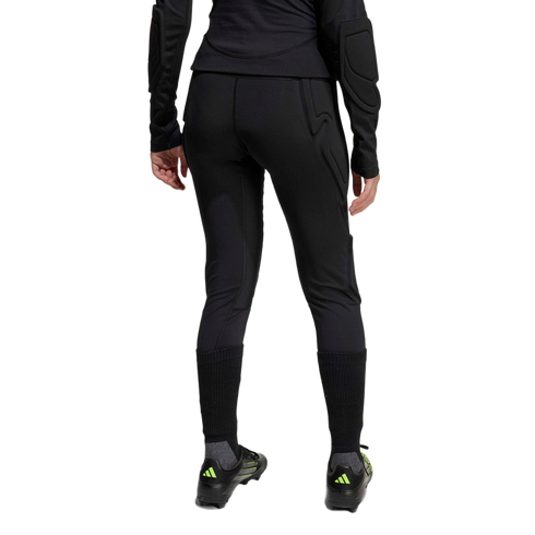 Rear view of a person wearing black padded athletic leggings, a long-sleeve padded top, tall black socks, and soccer cleats against a plain white background.