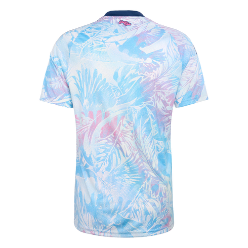 Back of a short-sleeved jersey with a light blue and pink tropical leaf print on white. It has a navy blue collar and small pink "Pura Vida" text at the top center.